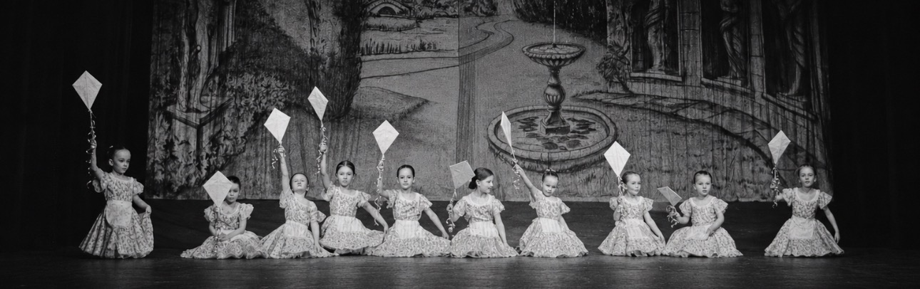 Young dancers in costume holding kites on stage